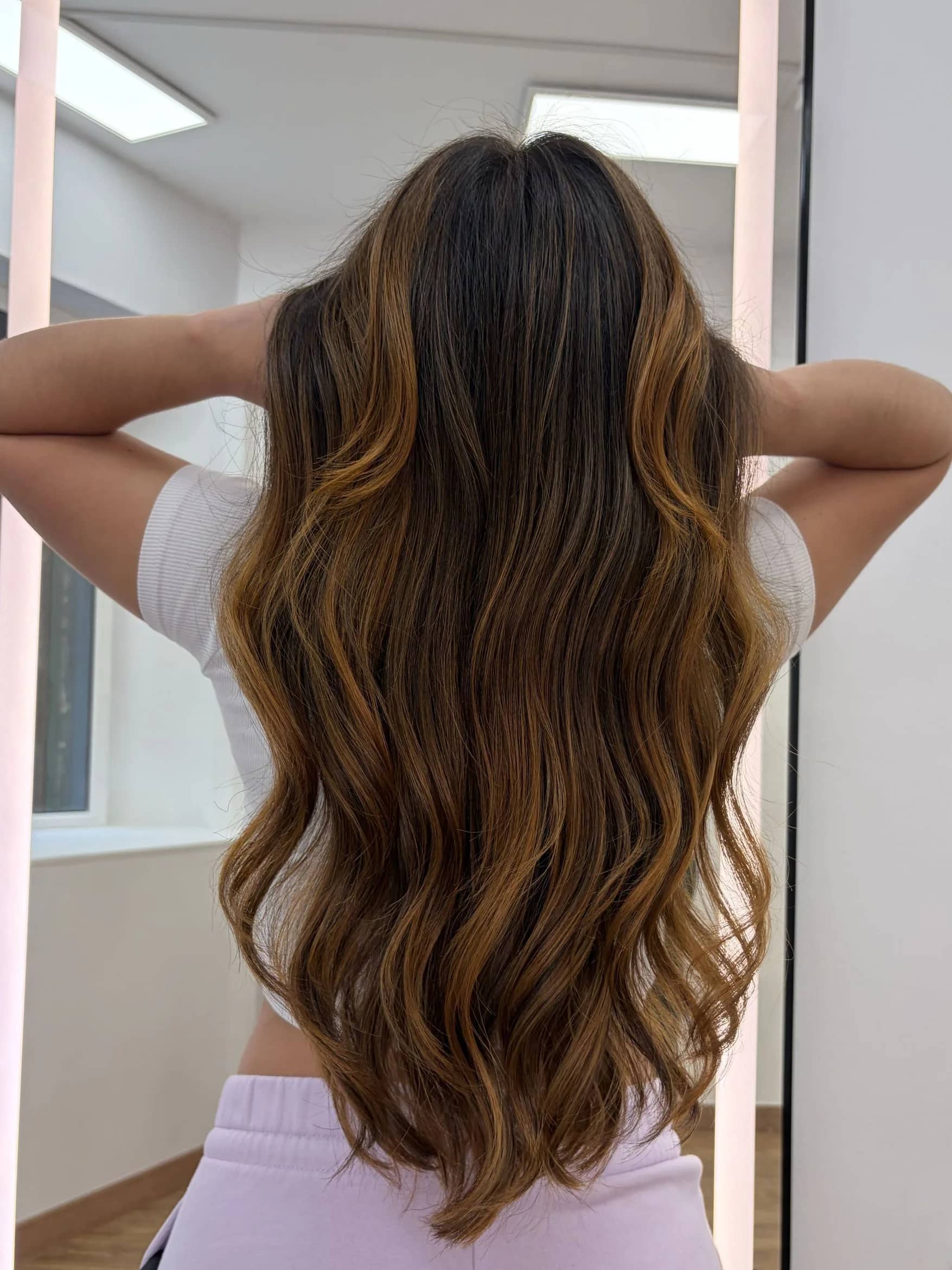 Balayage caramelo Barcelona Balayage caramelo en melena castaña larga con ondas naturales en Barcelona